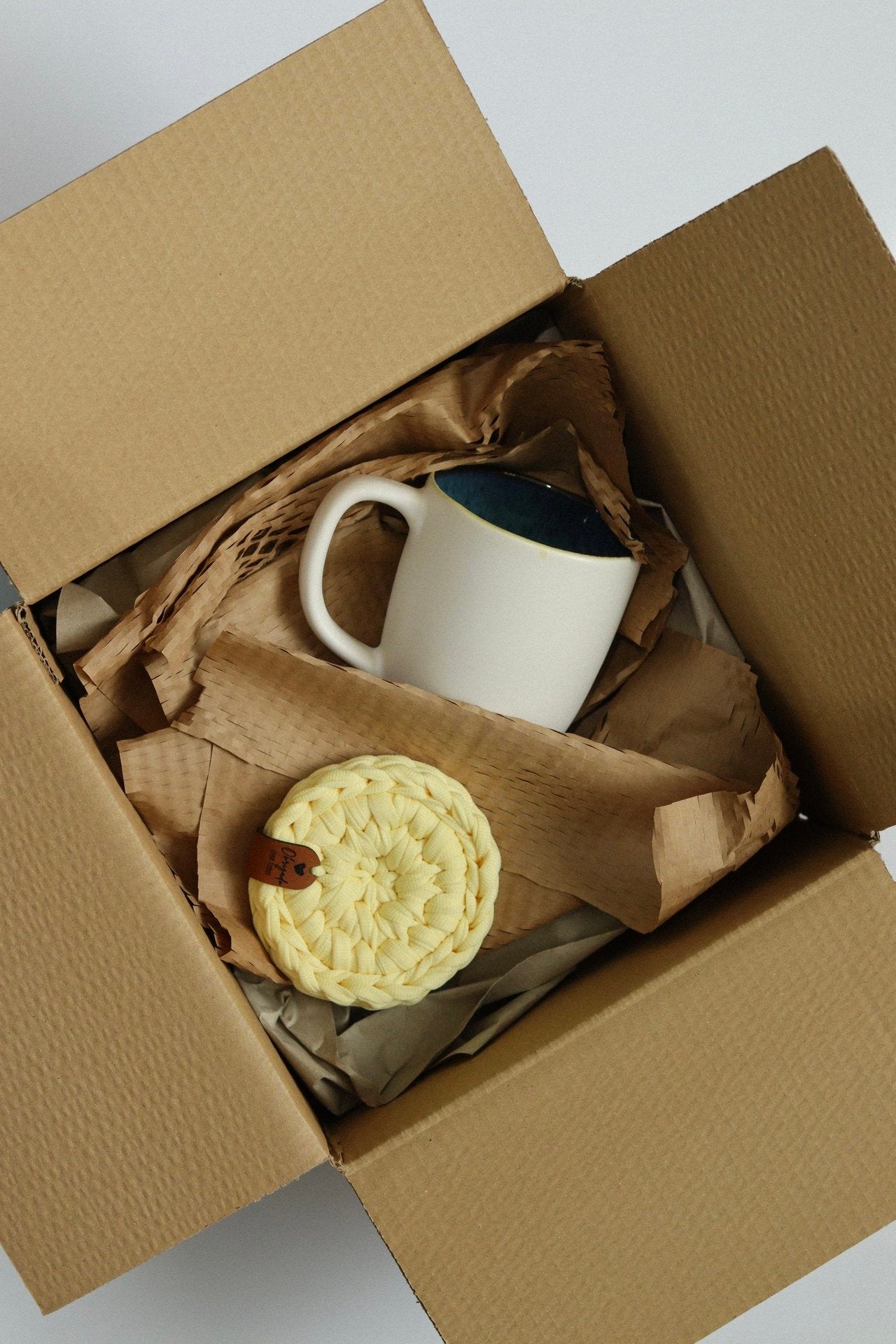 Conjunto de agradecimento com base amarela e caneca branca em embalagem artesanal.
