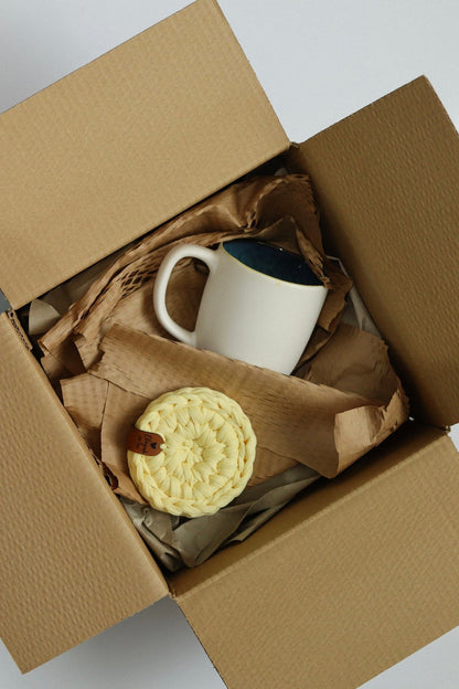 Conjunto de agradecimento com base amarela e caneca branca em embalagem artesanal.