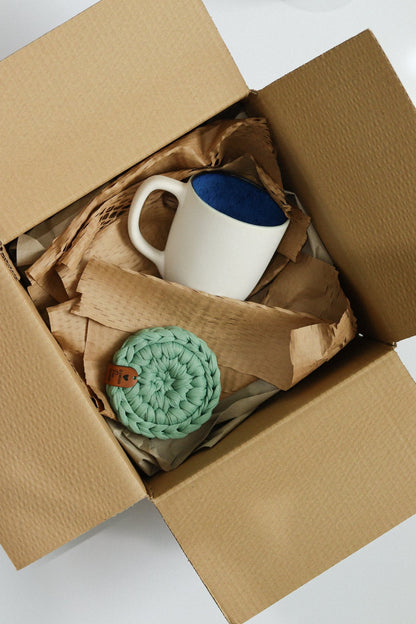 Sugestão de presente para o Dia do Pai com caneca branca e base em malha verde Ponto Bela em caixa de envio.