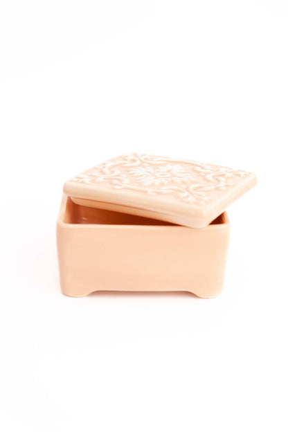 Caixa de joias ALMA em cerâmica rosa nude com tampa entreaberta, destacando o relevo floral artesanal e o tom suave da peça.
