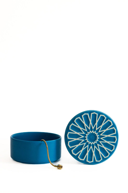Caixa de joias CARISMA azul claro em cerâmica artesanal, apresentada aberta com um detalhe de joia dourada no interior.