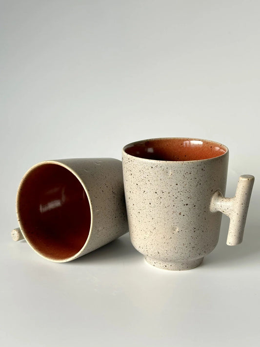 Vista lateral e superior da caneca TERRA 420ml, evidenciando a profundidade do tom vermelho e a robustez da cerâmica artesanal.