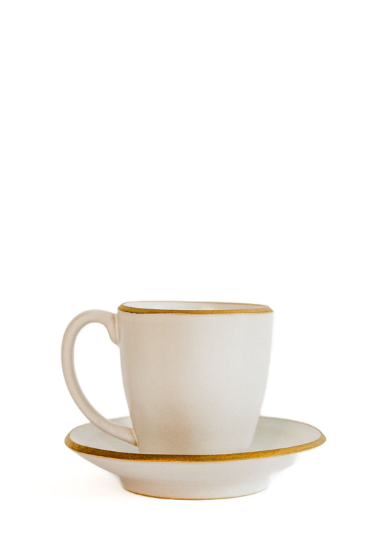 Conjunto de chávena e pires AURA em cerâmica marfim com detalhe em ouro, ideal para um serviço de café ou chá elegante e distinto.