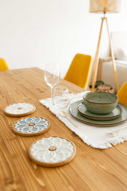 Mesa posta decorada com as três cores da Base Quente ALMA (branco, menta e azul), acompanhadas por loiça cerâmica e copos de cristal.