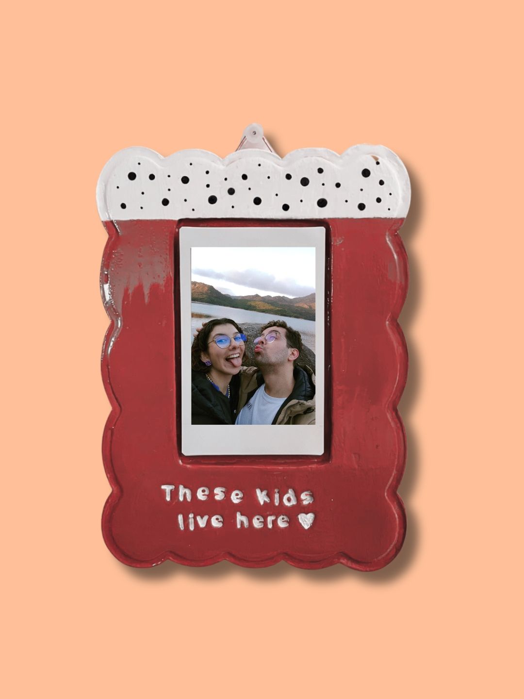 Moldura personalizada em cerâmica fria vermelha com fotografia de um casal e frase decorativa pintada à mão.