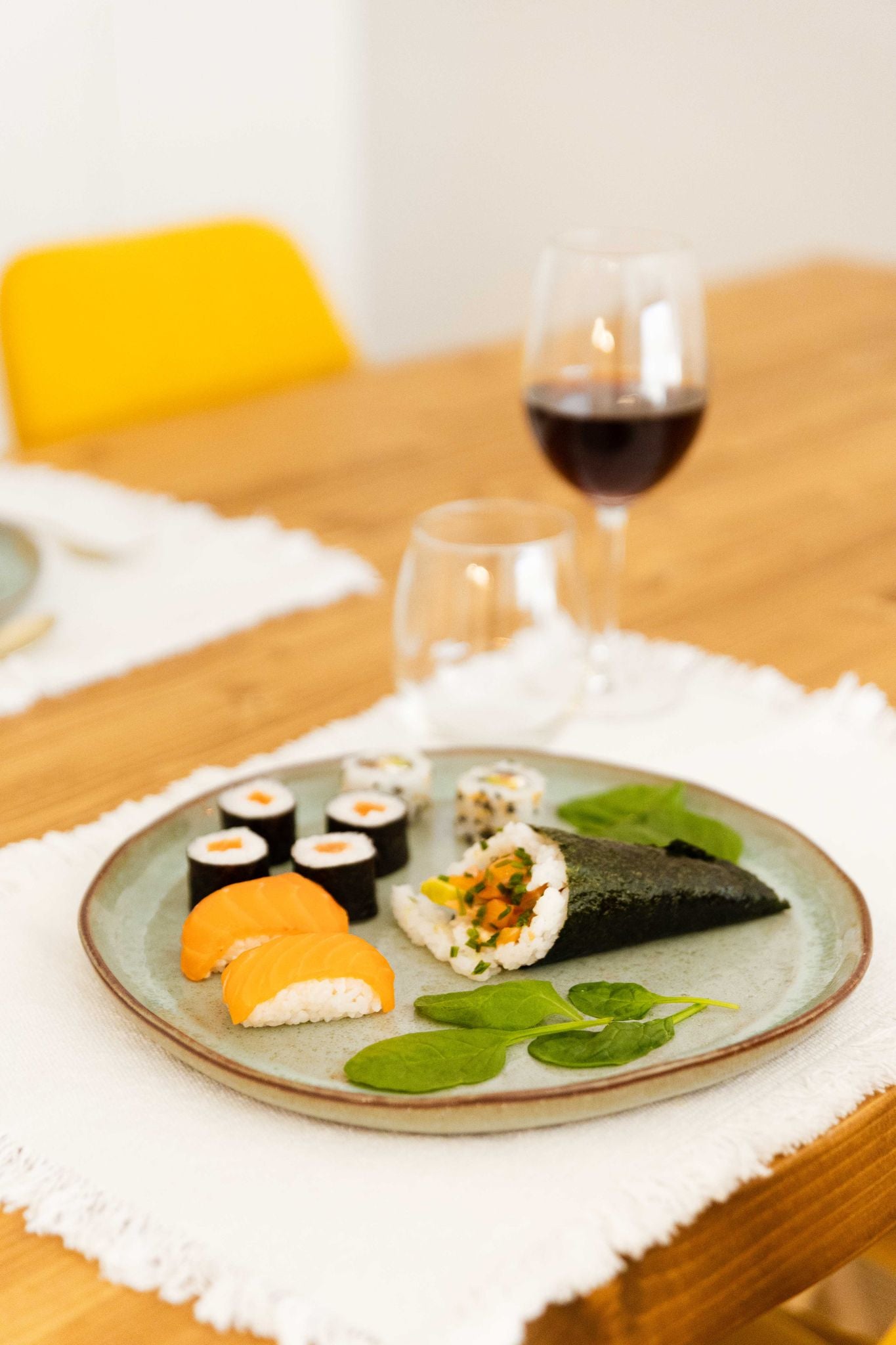 Prato de jantar SERENO verde servido com sushi numa mesa posta elegante, demonstrando a versatilidade da peça para diferentes tipos de gastronomia.